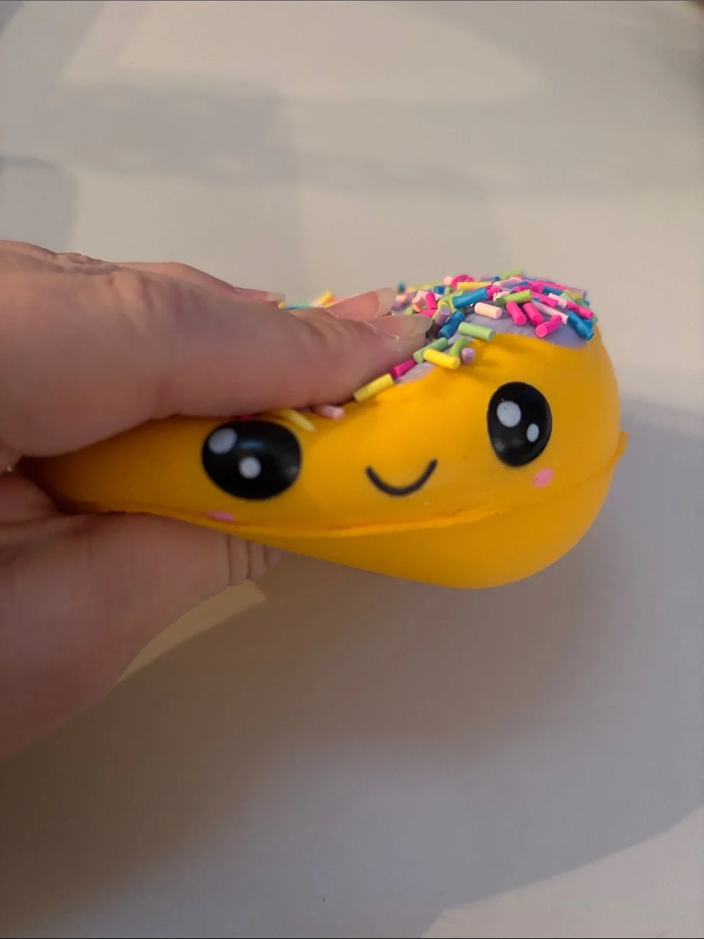 Smiling Yellow Donut Plush Toy with Purple Frosting and Rainbow Sprinkles